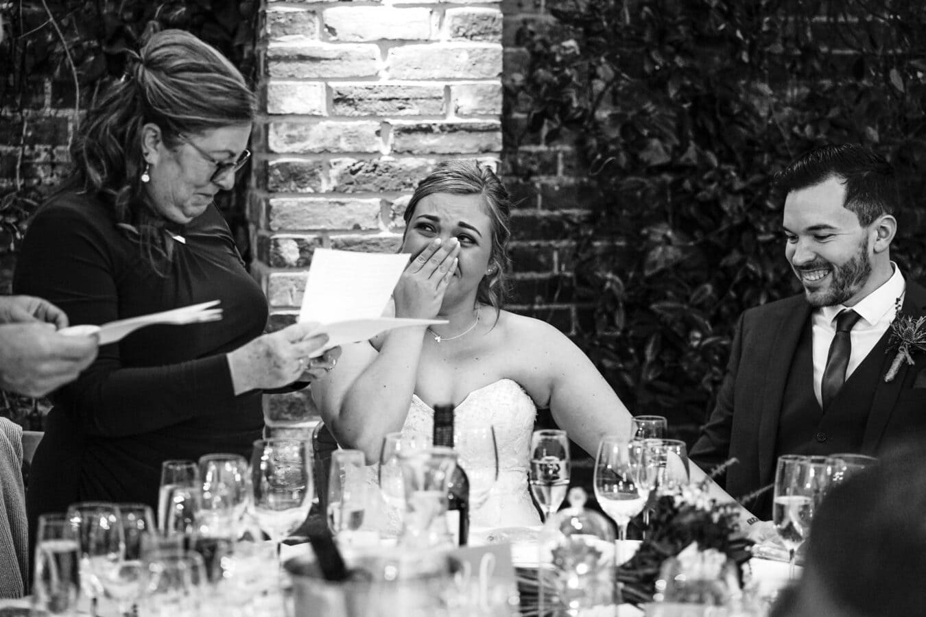 Real wedding moments of a bride crying during the wedding speech given by her mum and dad